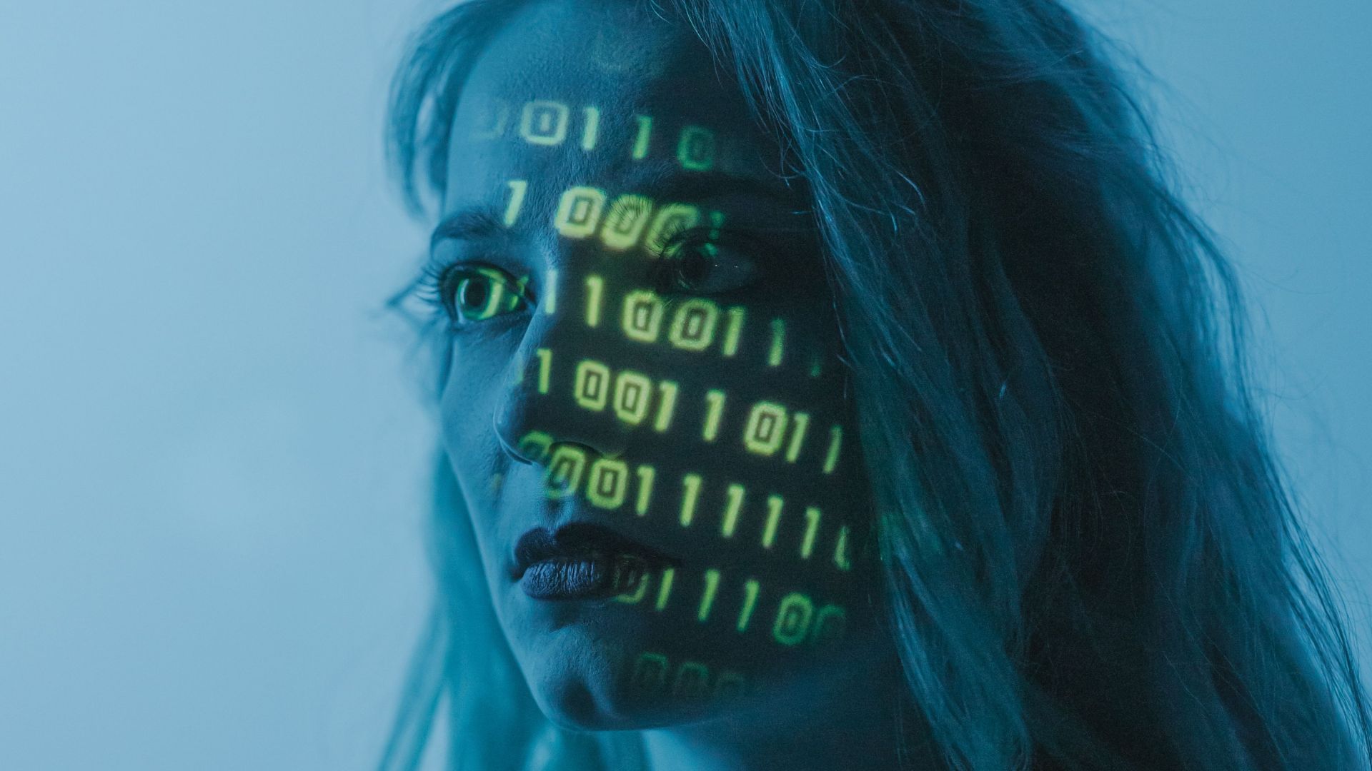 Stylized portrait of a woman with binary code projected on her face, evoking themes of technology and identity.
