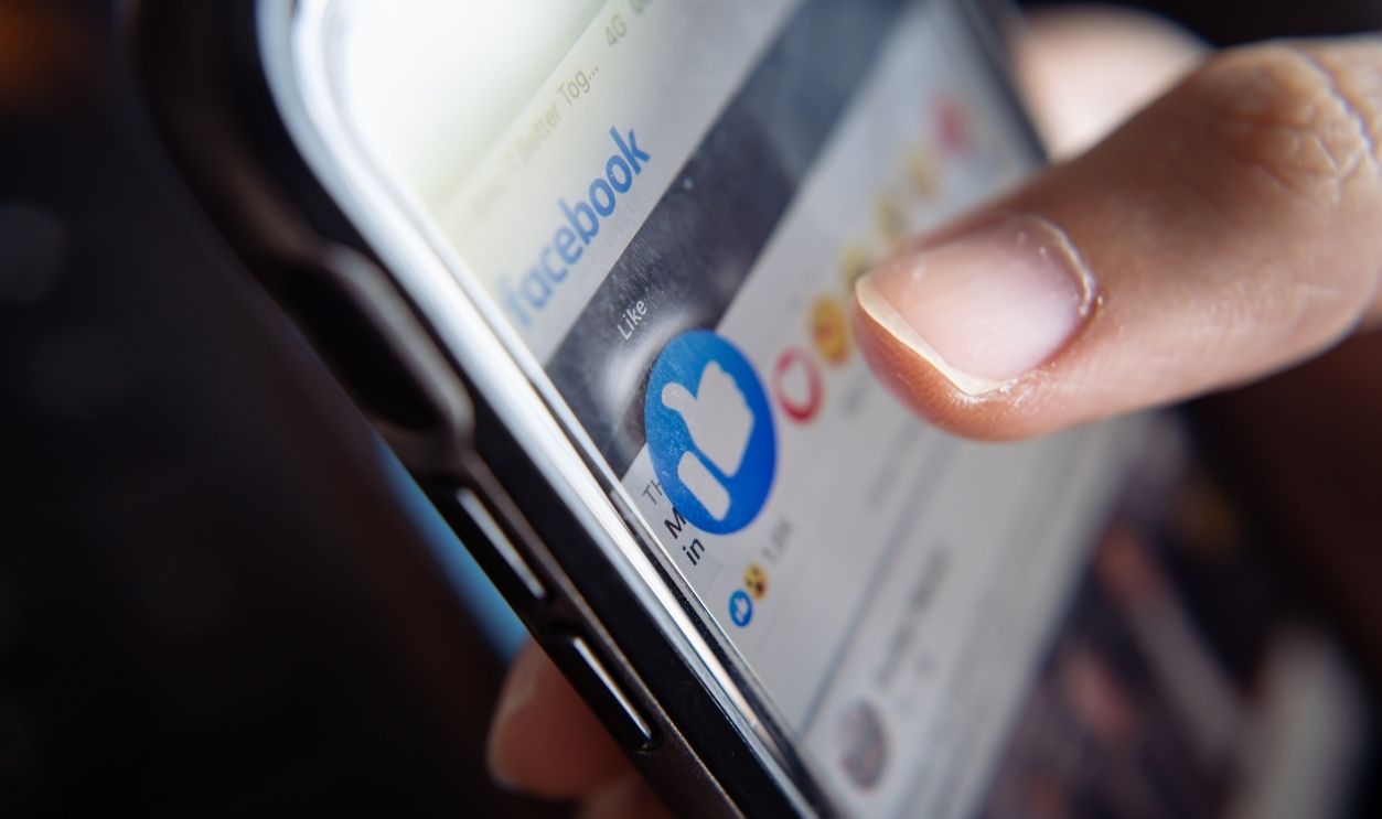 Bangkok, Thailand - January 10, 2021 : Facebook user touches on the like button in Facebook app.