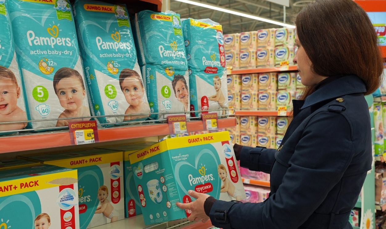 Woman chooses diapers Pampers at supermarket. Mom buys baby diapers. Minsk, Belarus - may 2022