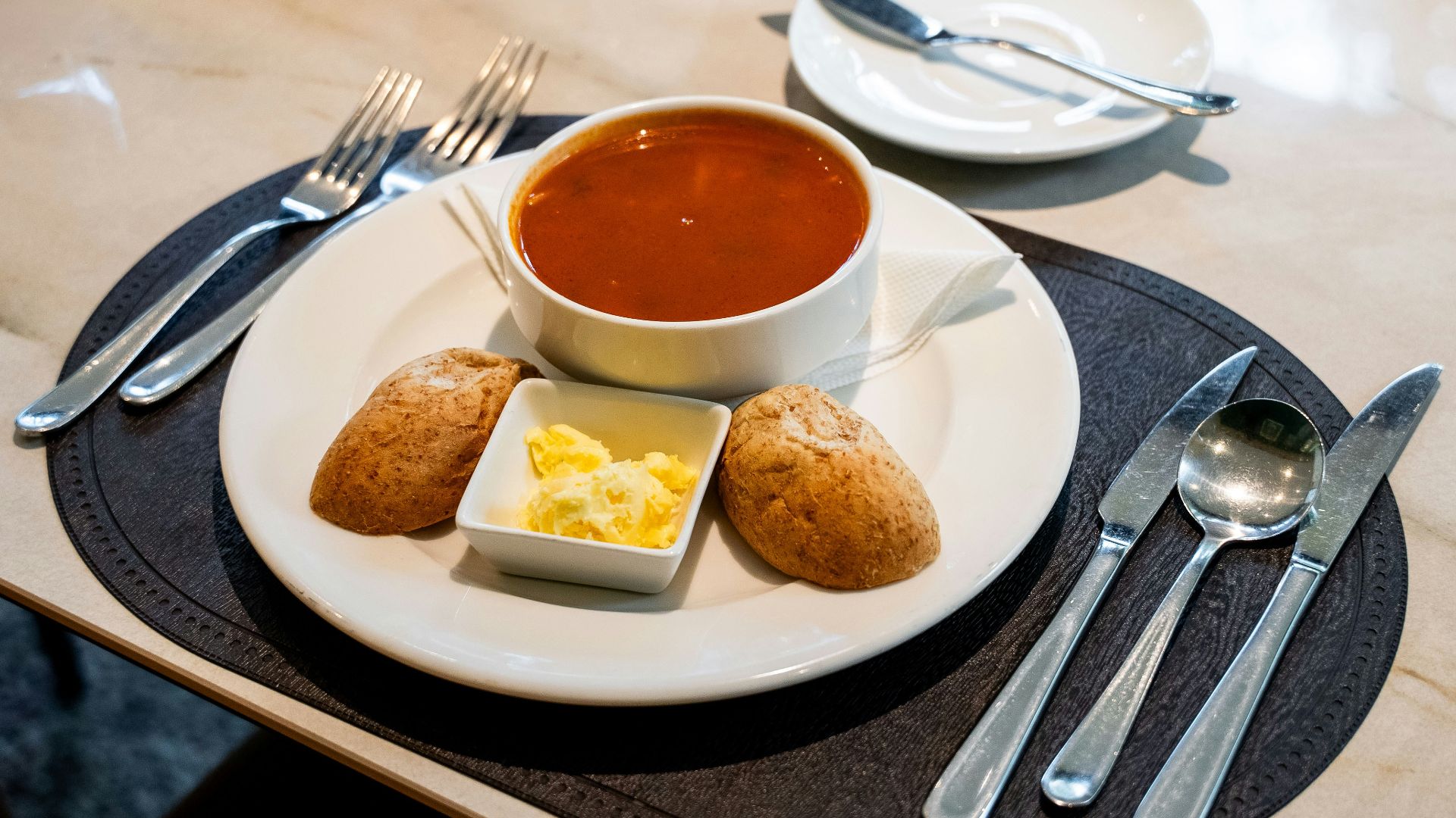 Bowl of tomato soup with bread and butter