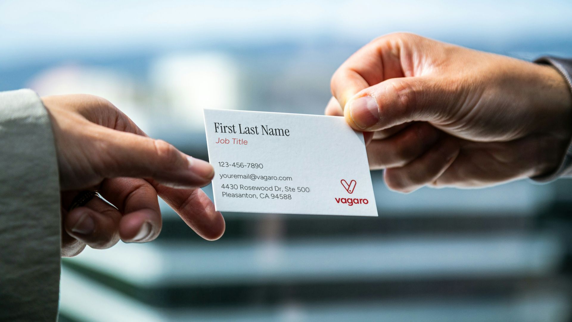 Two hands exchanging a business card