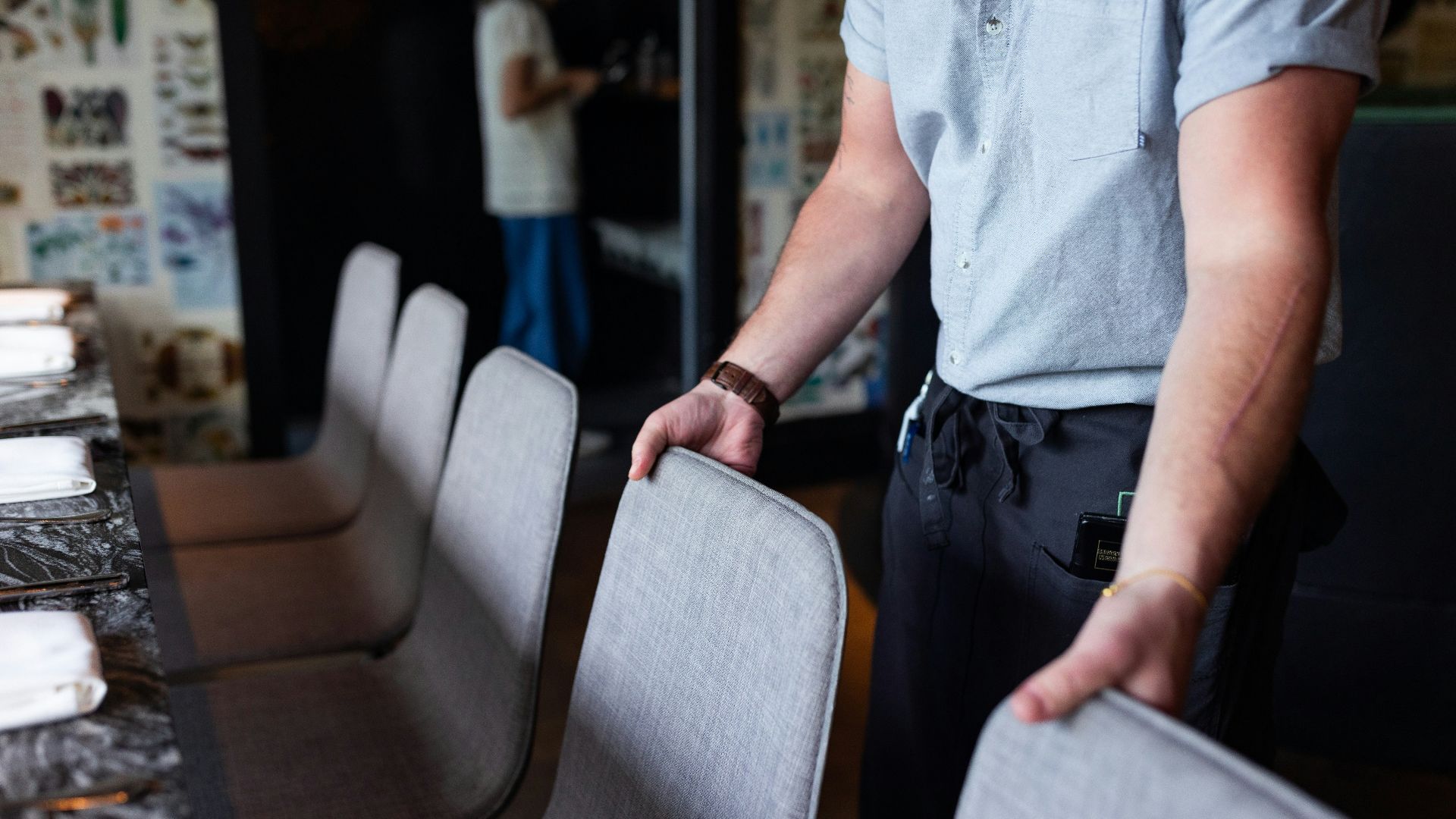 A man standing next to a table with a bunch of chairs