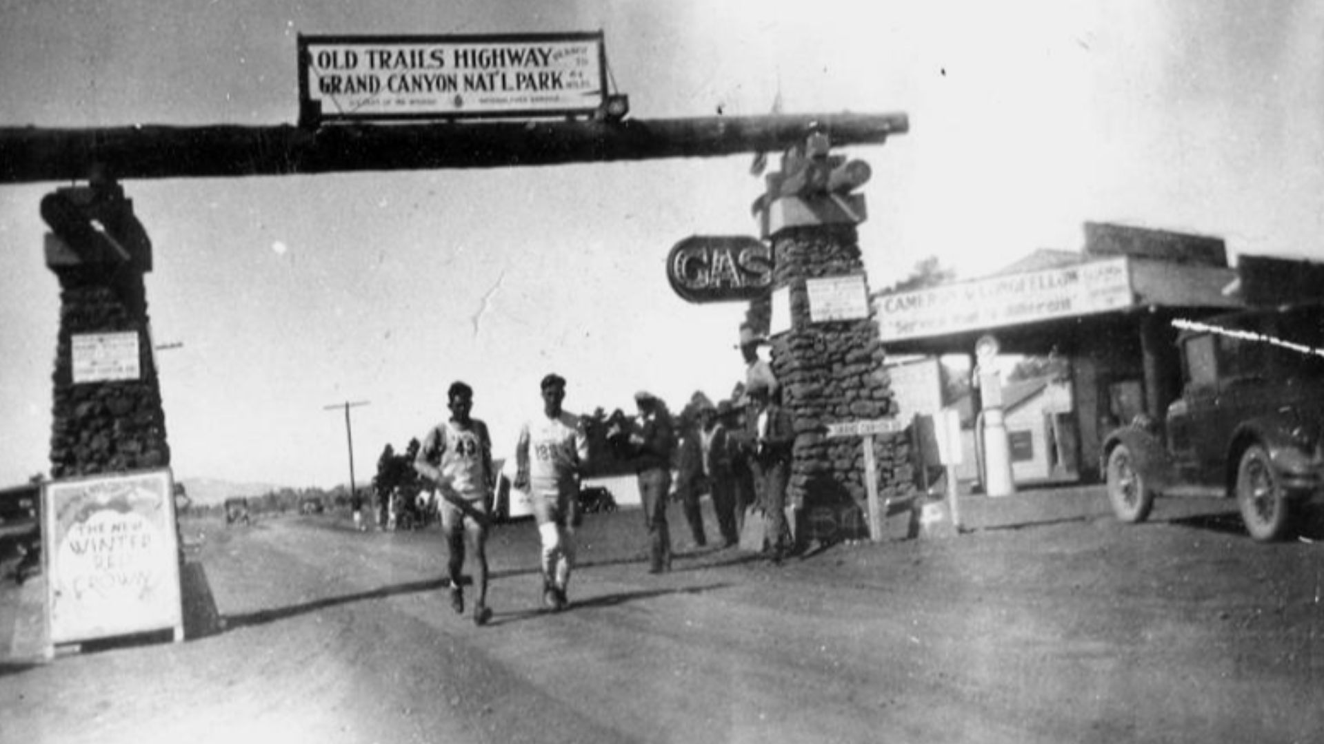 This photo was taken on March 17th, 1928 during the historic 3422 mile Coast-to-Coast run across America (Los Angeles to New York City, fondly known as the Bunion Derby. This was segment from Williams to Flagstaff. Pictured on left, Andy Payne (43) and on