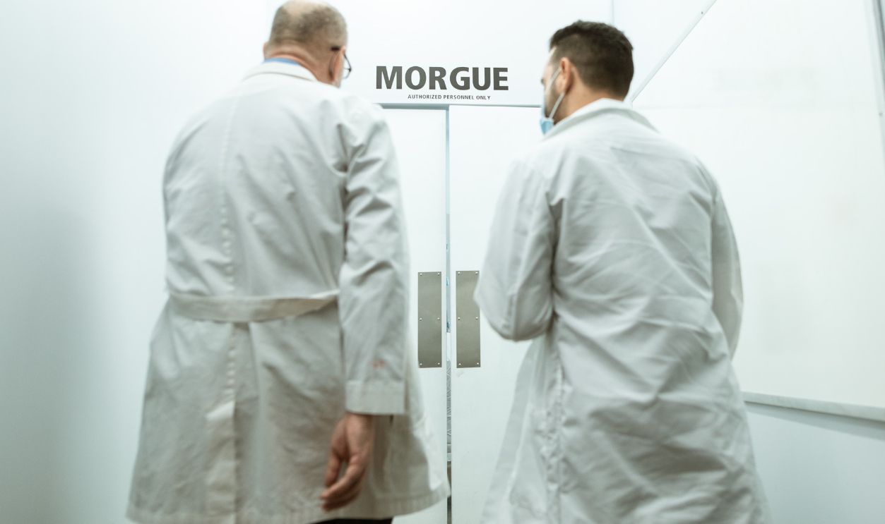 Two doctors entering a morgue, emphasizing a clinical and somber atmosphere