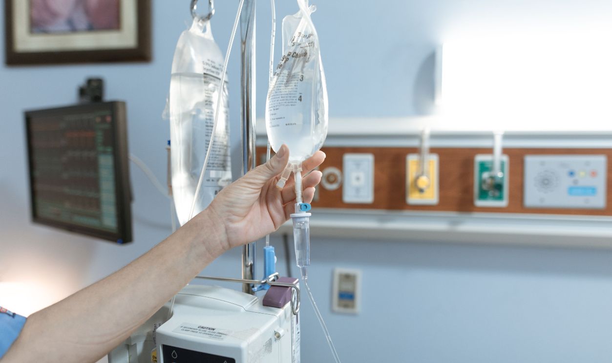 Close-up image of an IV drip and hand in a hospital room