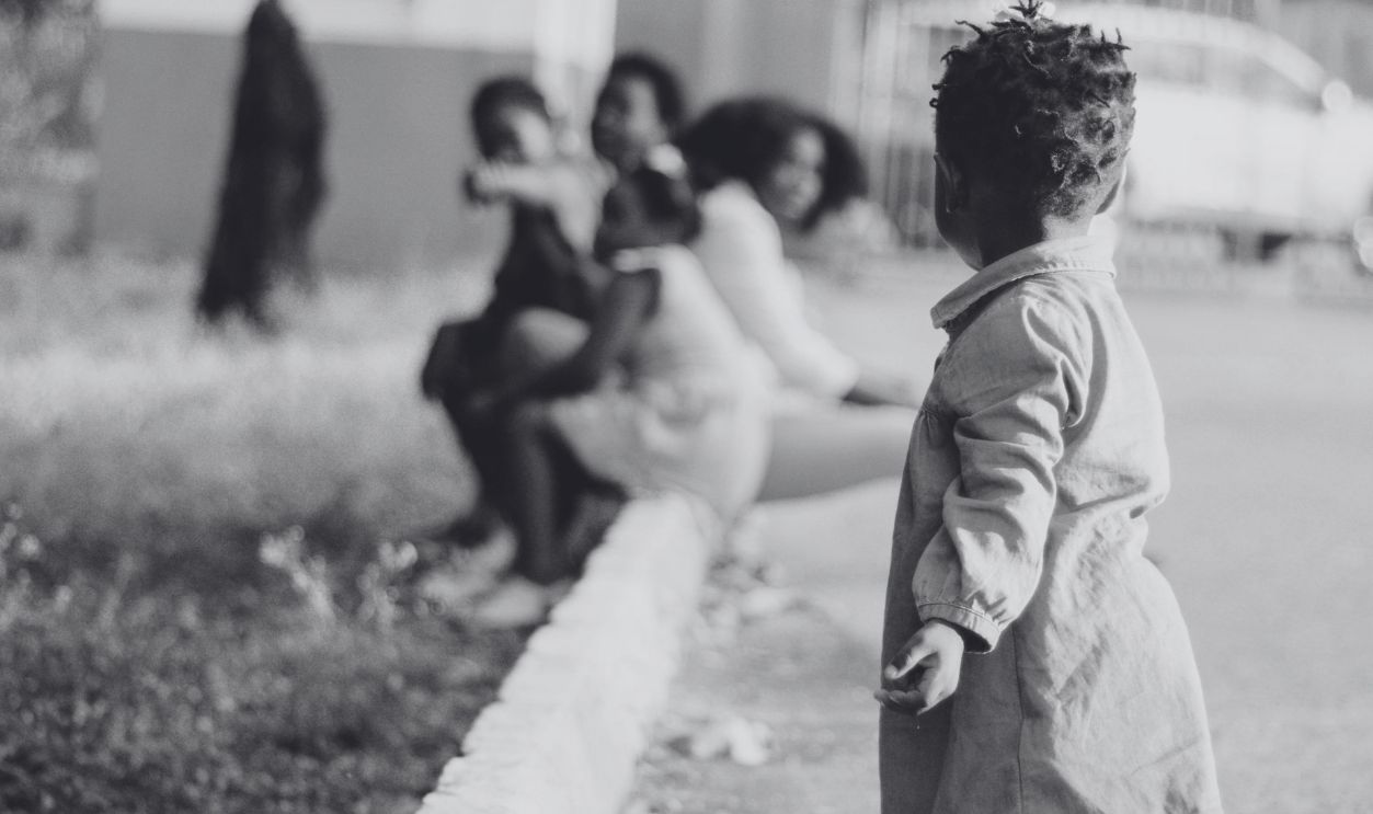 A cute toddler with curly hair explores outdoors