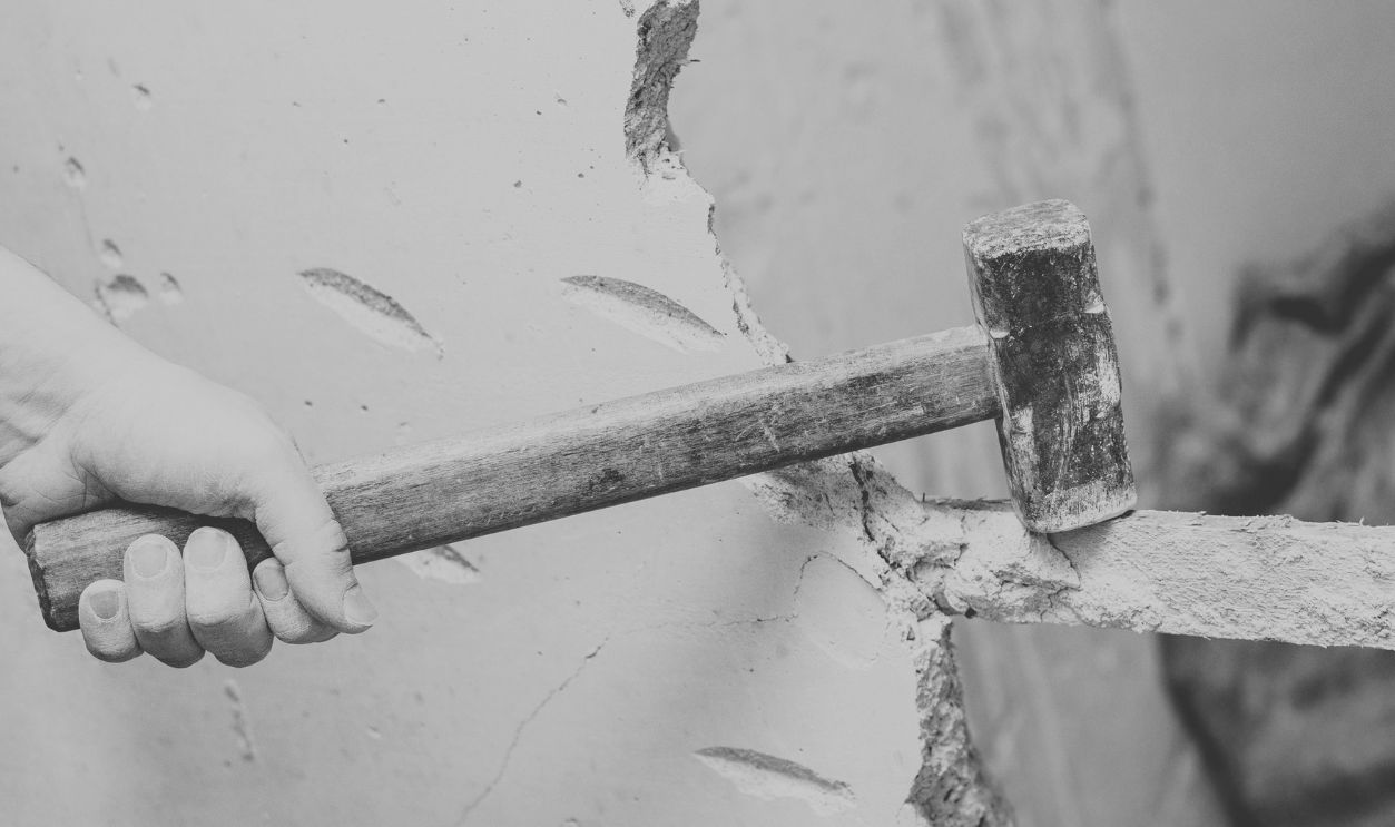 demolition work and rearrangement. worker with sledgehammer destroying wall