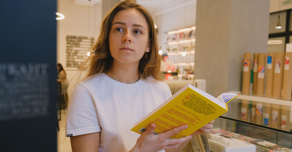 a-woman-in-white-t-shirt-holding-a-yellow-book