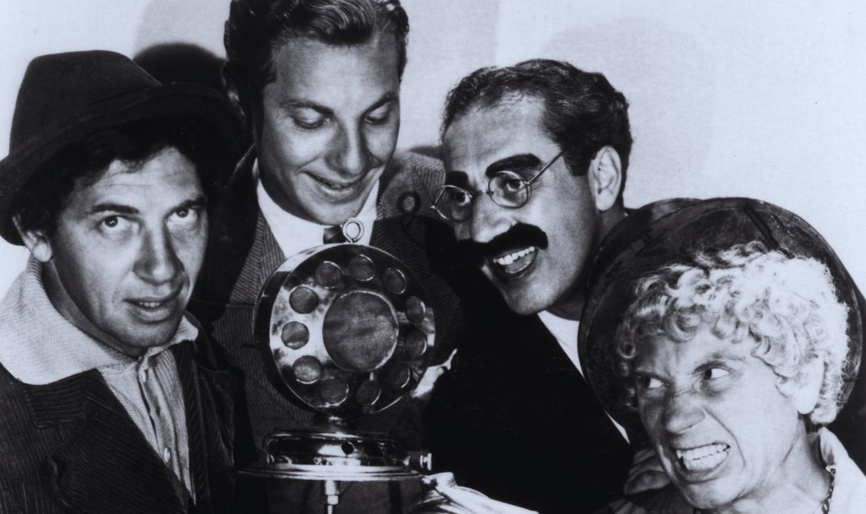 Gettyimages - 3227525, Marx Quartet circa 1935: Promotional portrait of the Marx Brothers (left - right, Chico, Zeppo, Groucho, and Harpo) clowning around a microphone. Harpo is holding a fumigator.