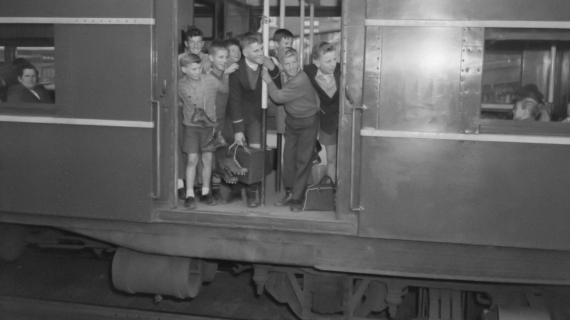 a black and white photo of a group of people on a train