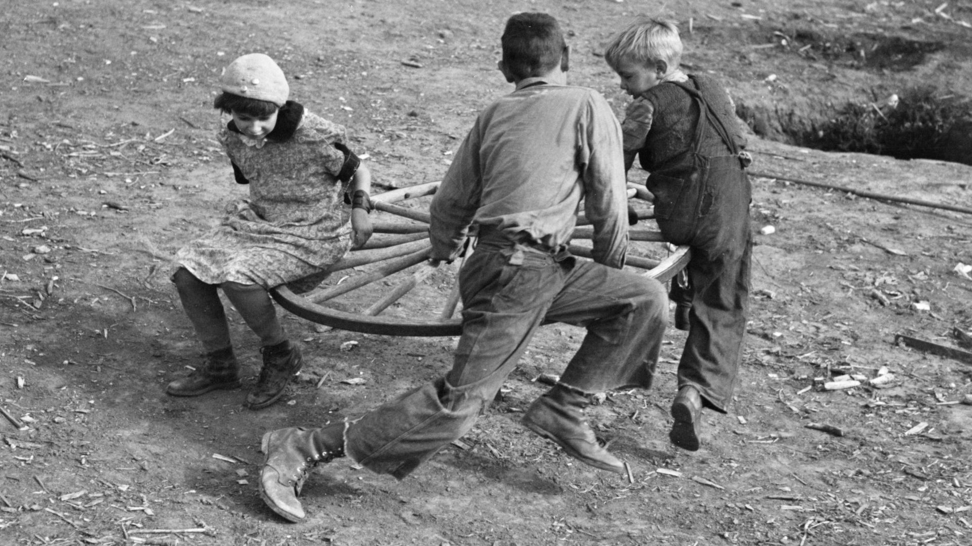 Farm children playing on homemade merry-go-round, Williams County, North Dakota.