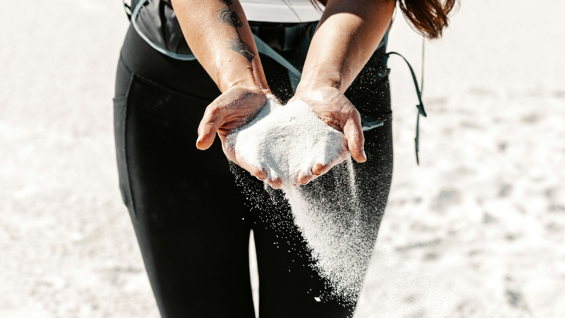 Woman holding sand slipping through her hands