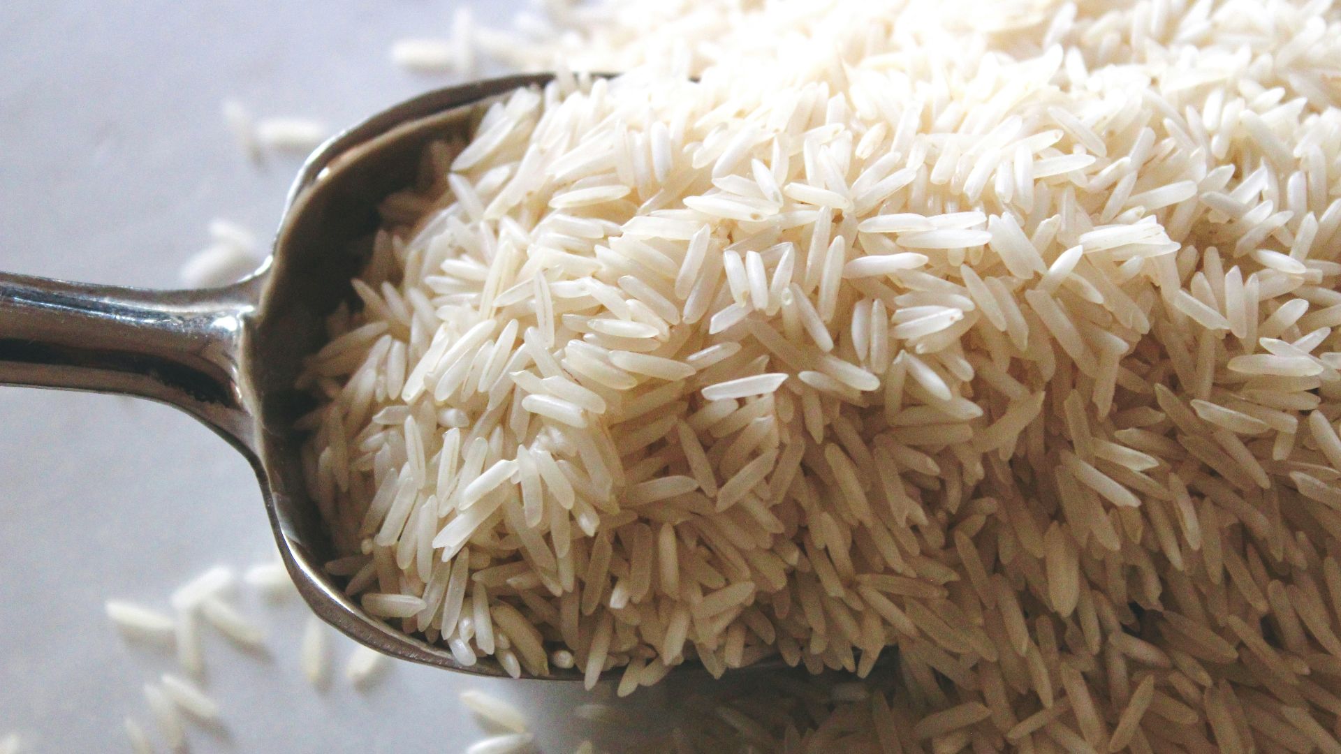 a spoon filled with rice on top of a table