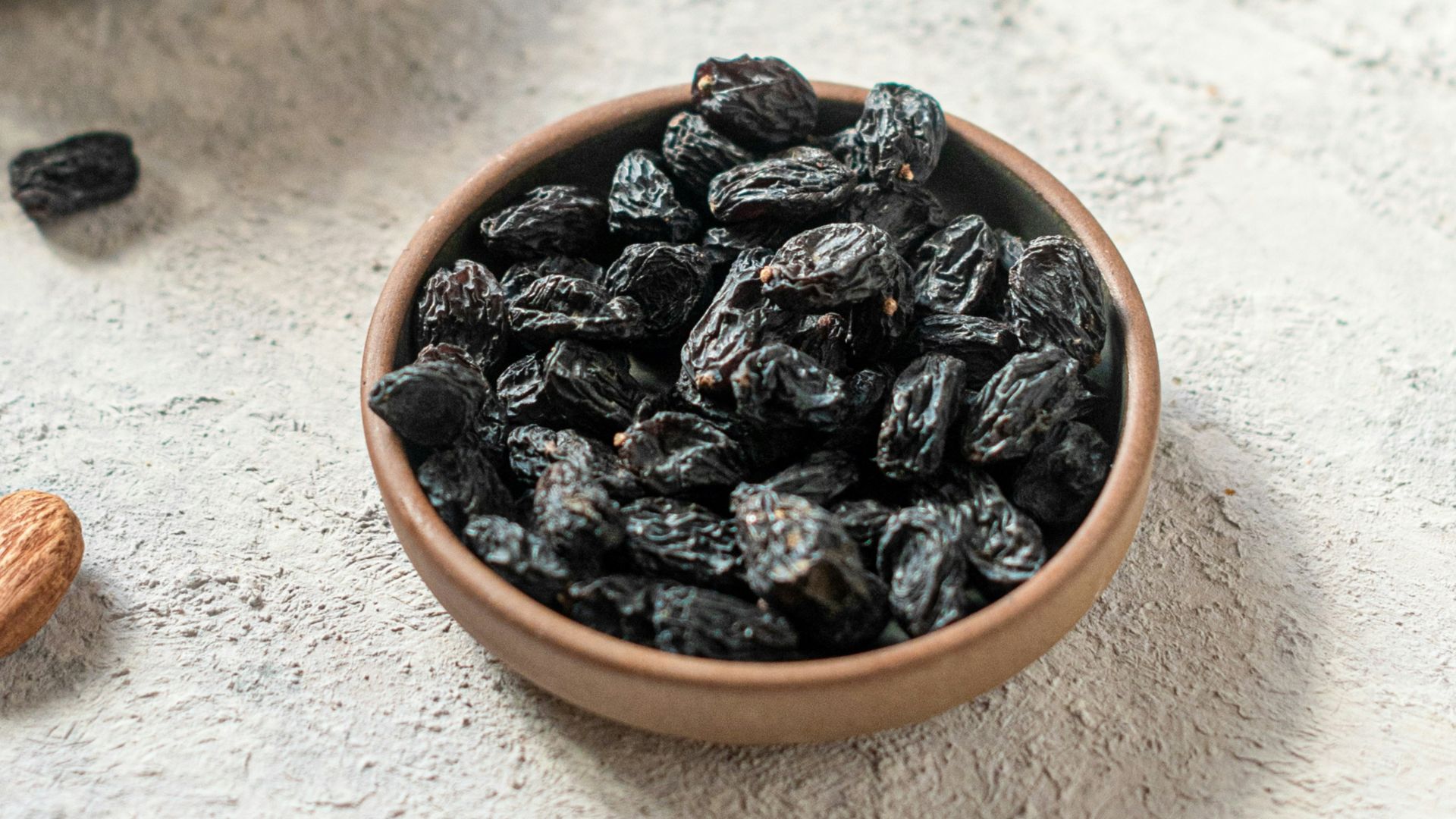 brown and black coffee beans on white ceramic bowl
