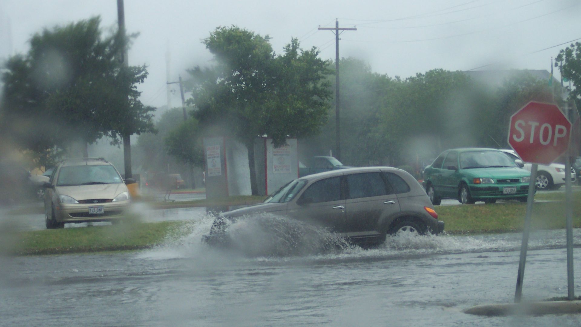 A vehicle passes through a city street affected by flash flooding in San Marcos, Texas.