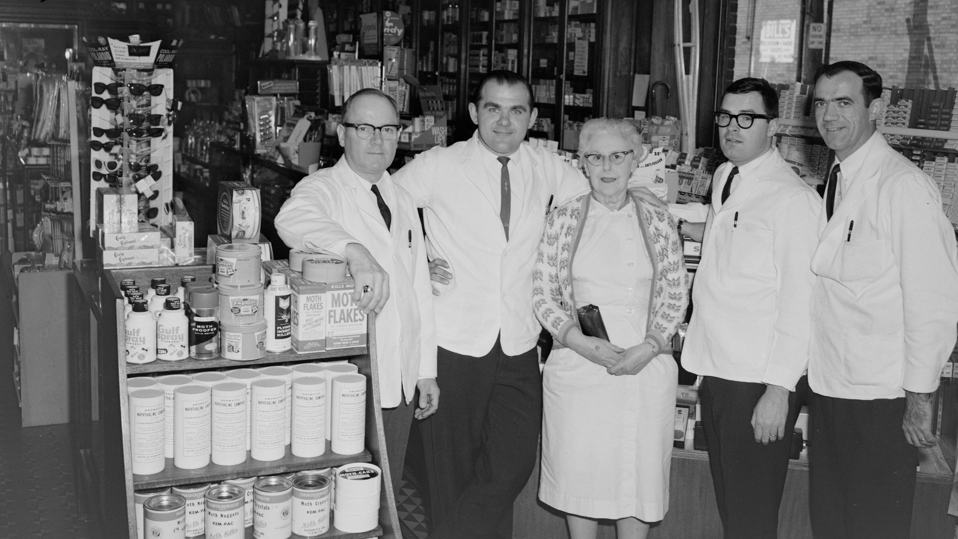 group of men in white uniform standing in front of store