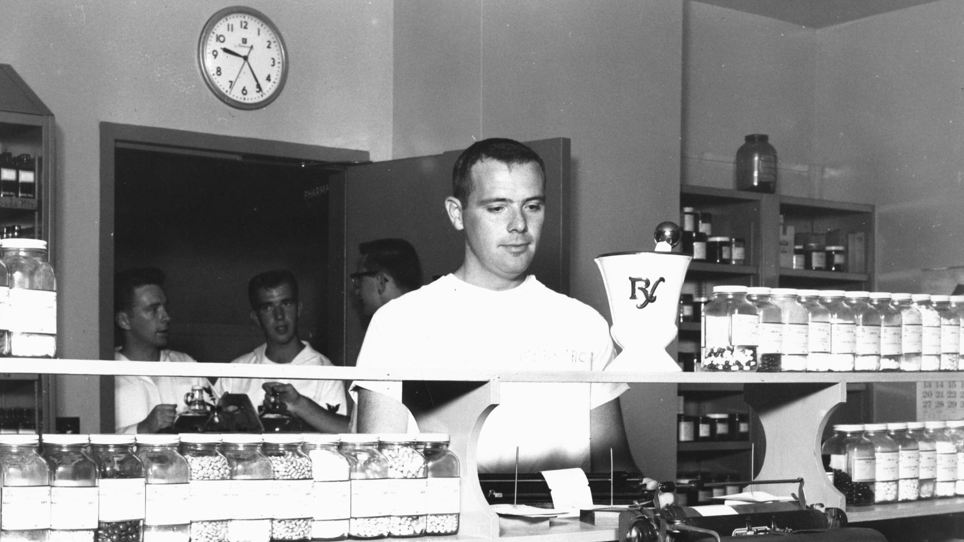 Men working behind a counter in a store.