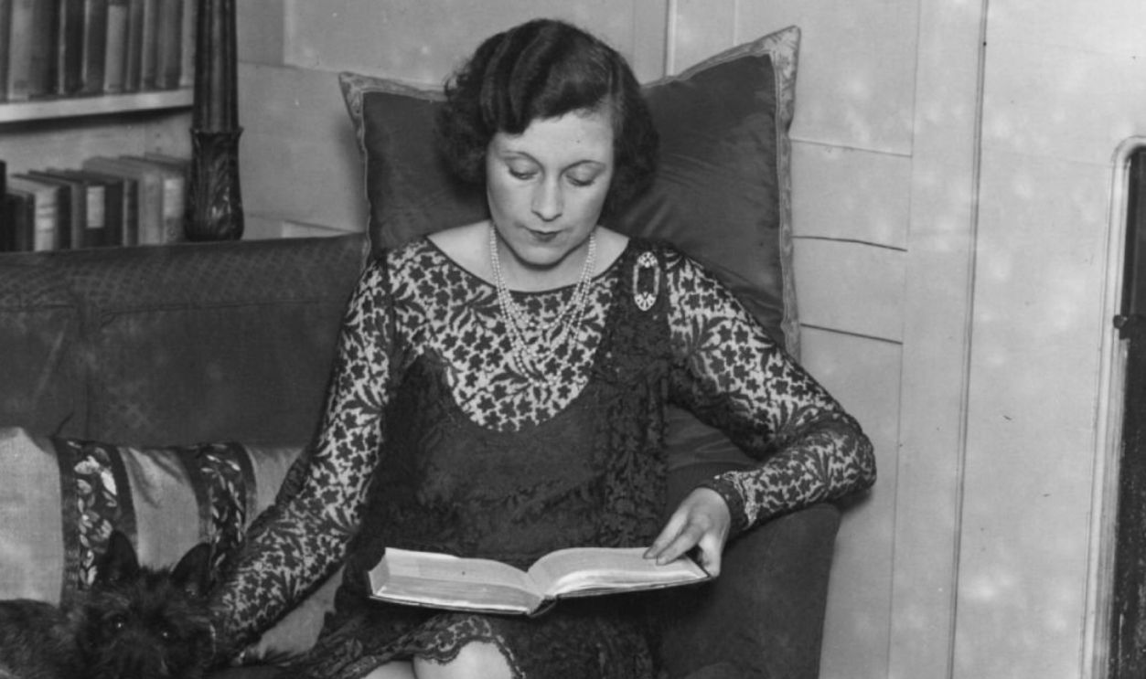 circa 1928: Mrs McCorquodale (Barbara Cartland, 1901 - 2000) reading at home.