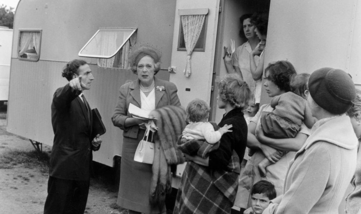 18th August 1961: British writer Barbara Cartland (1901 - 2000) visiting travellers at a Romany camp on Colony Heath. 