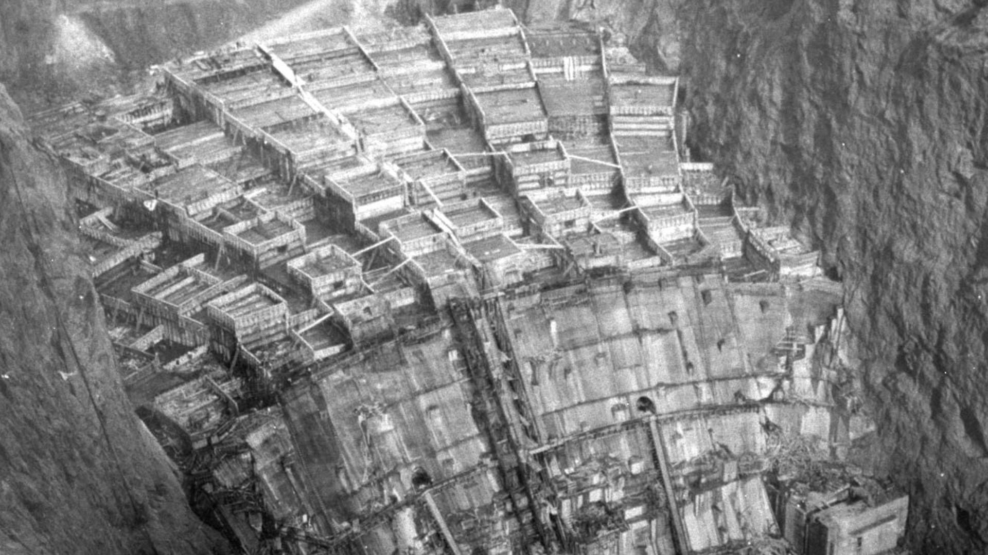 Hoover Dam takes shape from the concrete columns in which it was poured (shot from cableway control tower downstream on Nevada rim, so looking upstream)