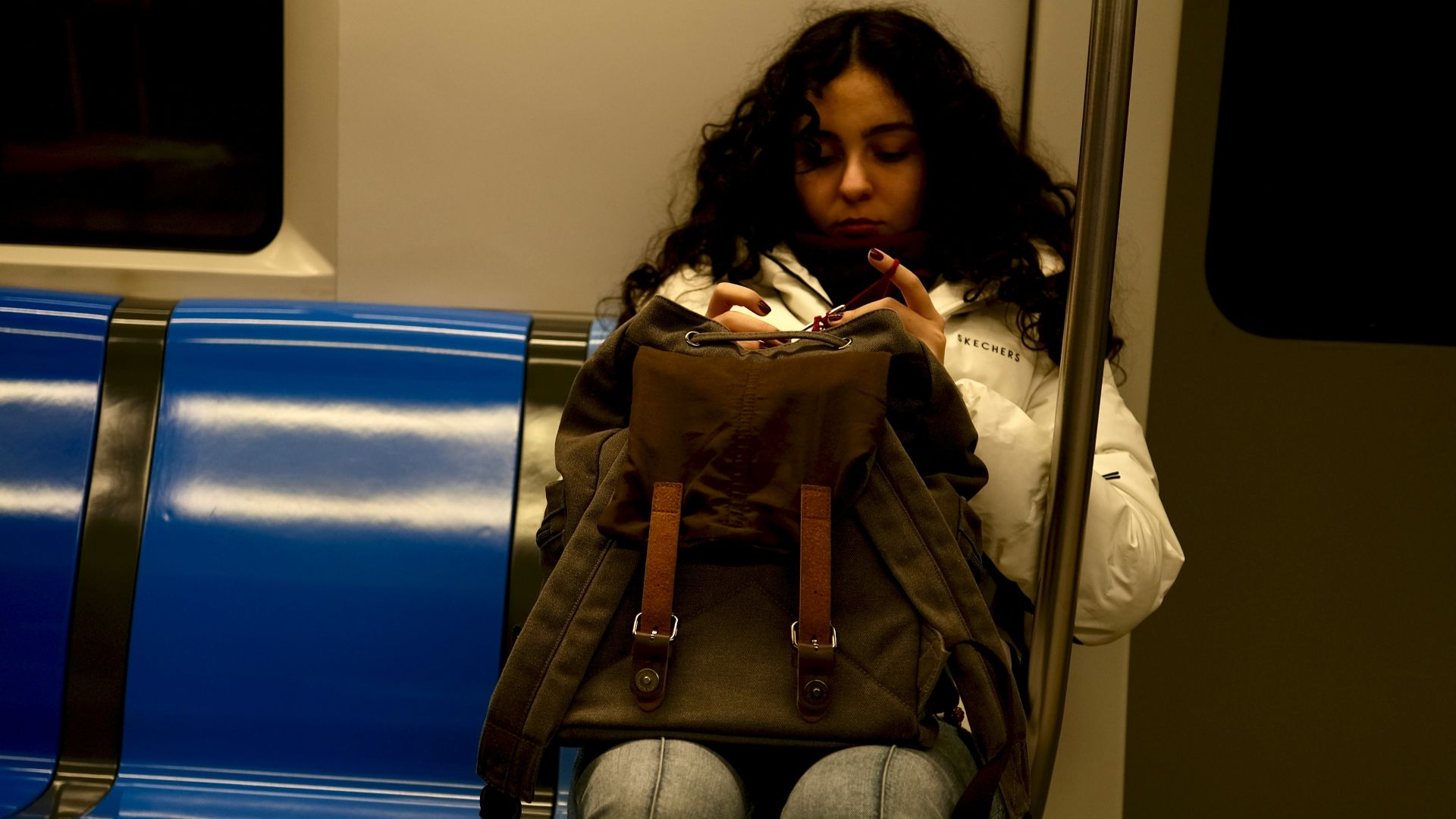 Woman on a train looking in her backpack