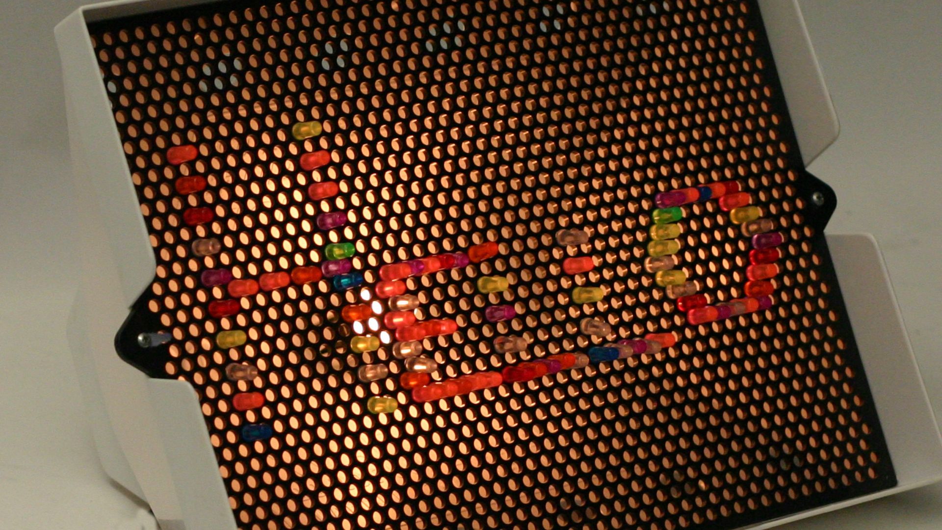 A Lite-Brite (without black paper) spelling