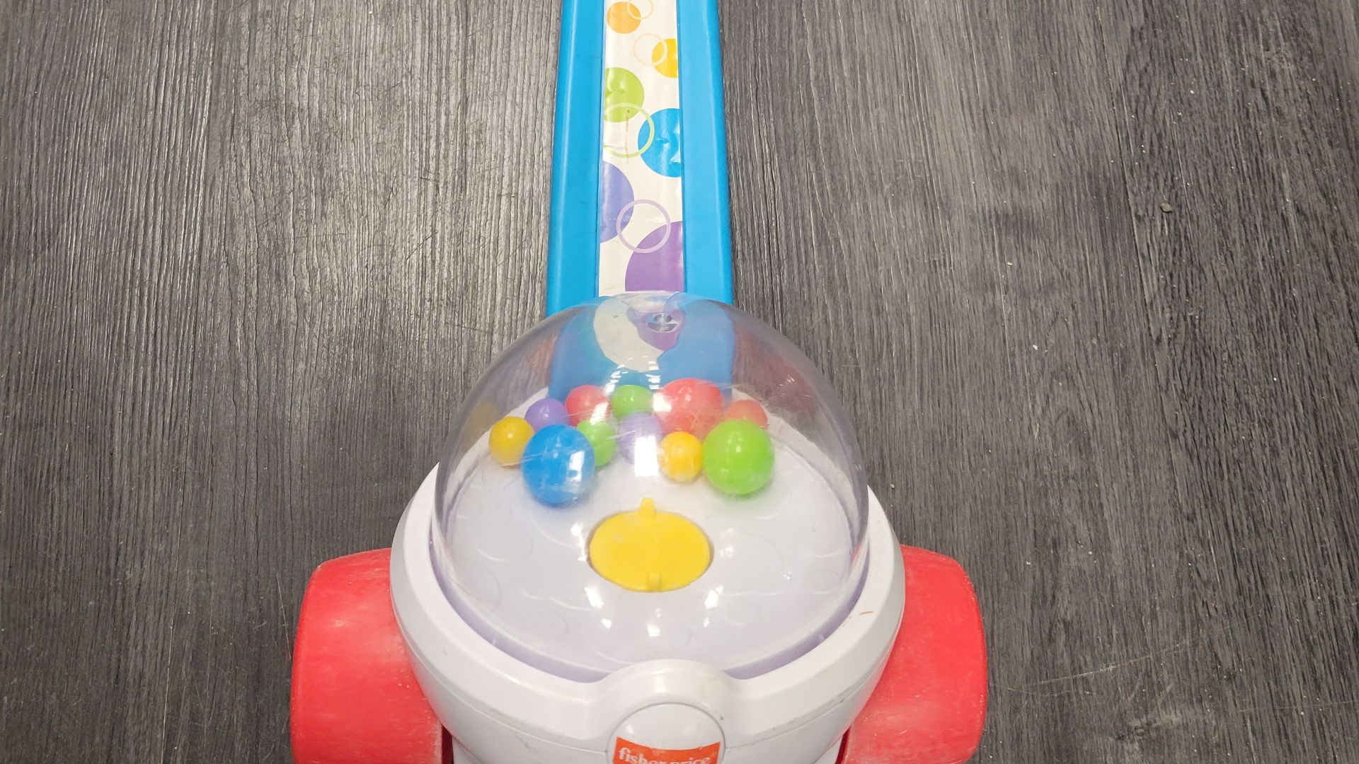 A photograph of a Corn Popper toy, laying flat on the ground