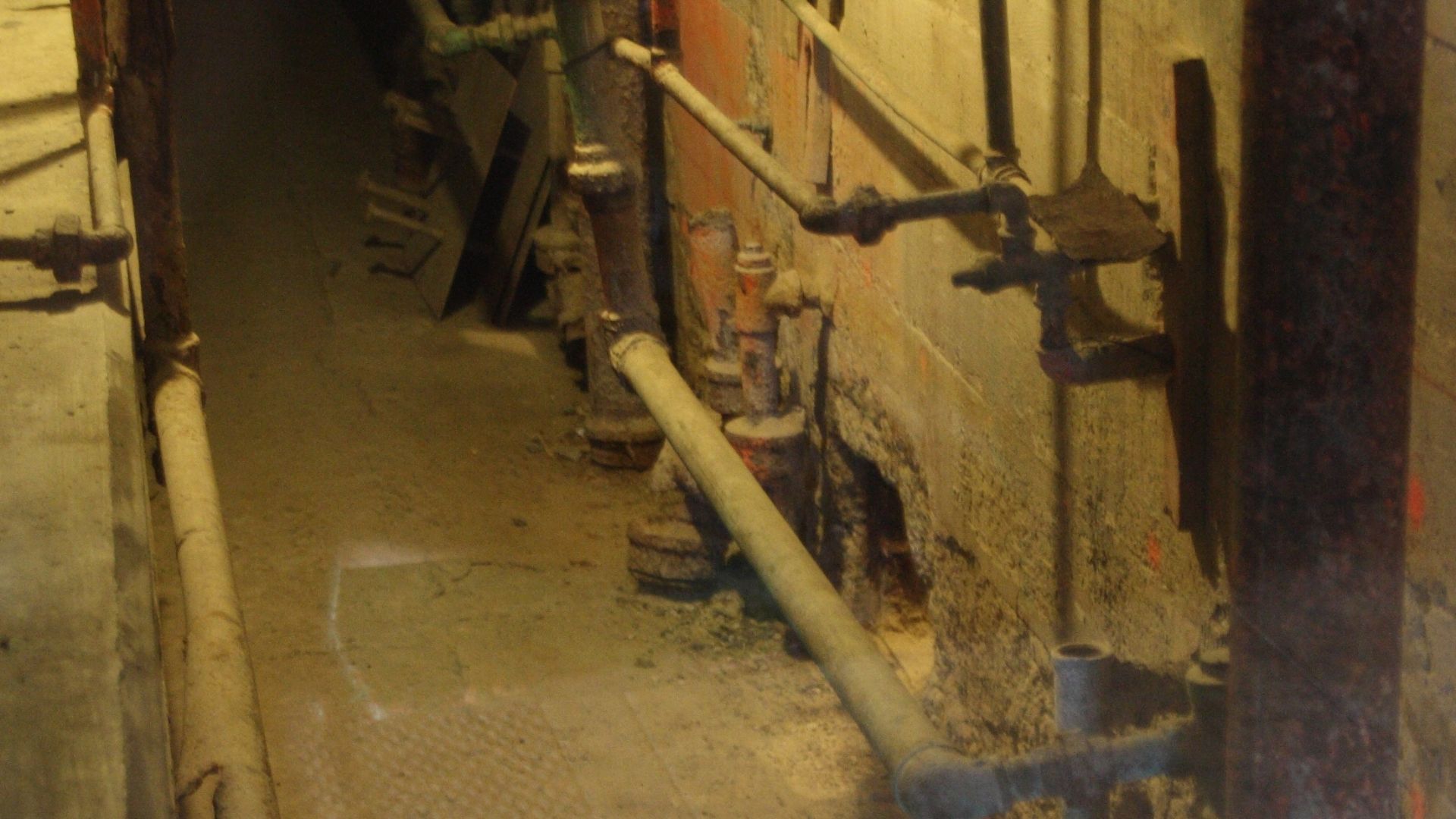 The utility corridor used in the 1962 escape, showing the two holes from cells. Picture taken through glass.