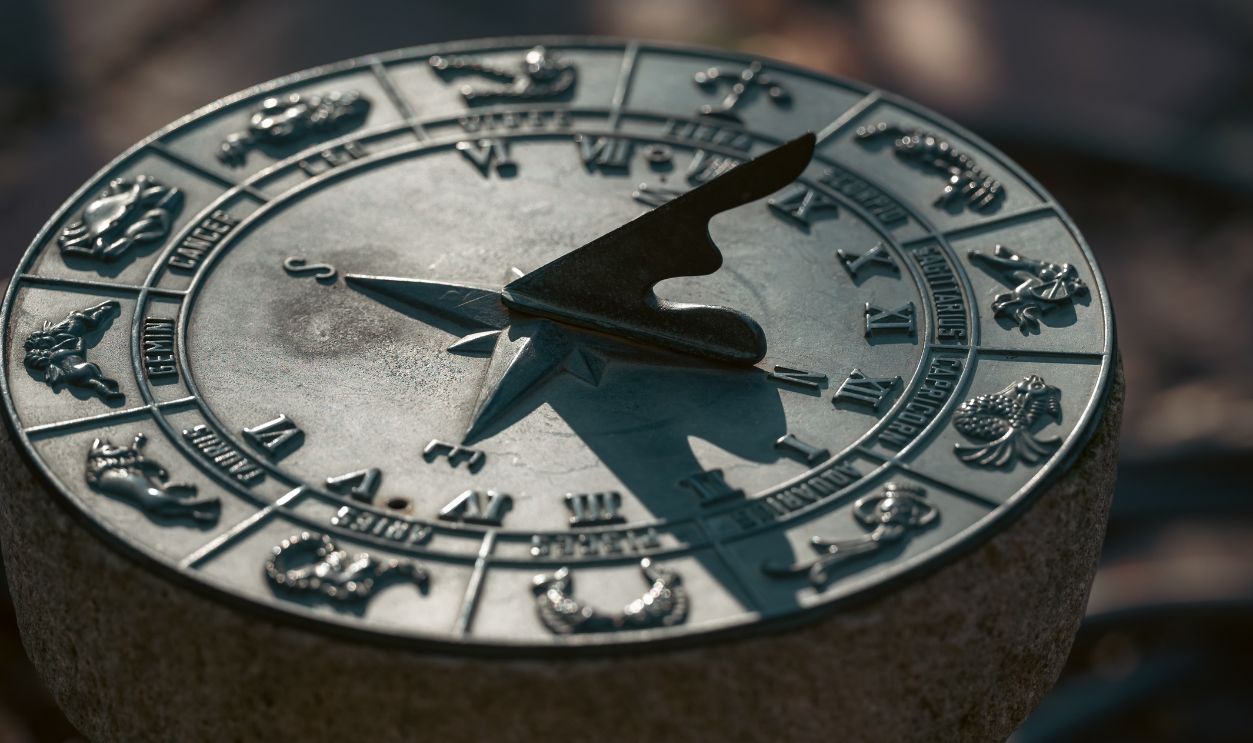 Detailed image of an antique sundial featuring zodiac symbols under natural light