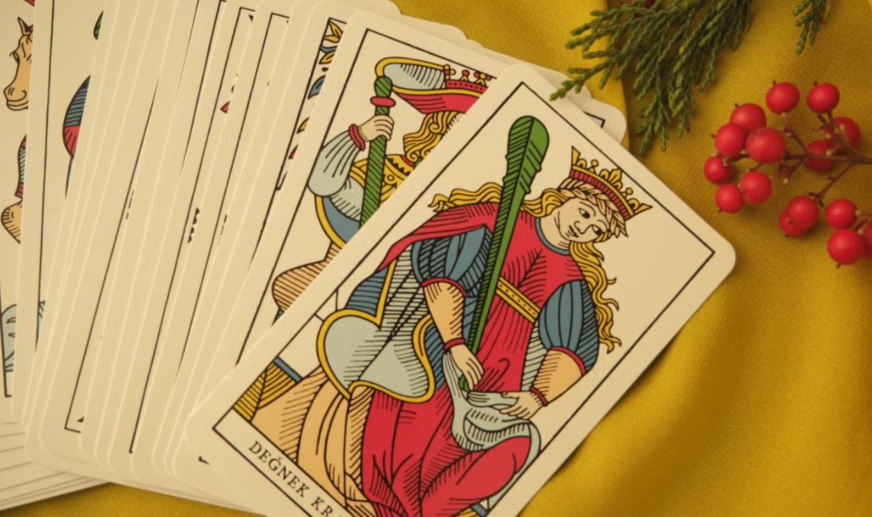 Tarot cards featuring Degnek Kralicesi on fabric with red berries