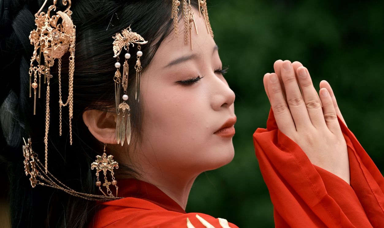 Beautiful side profile portrait of a woman in traditional red attire with ornate headpiece