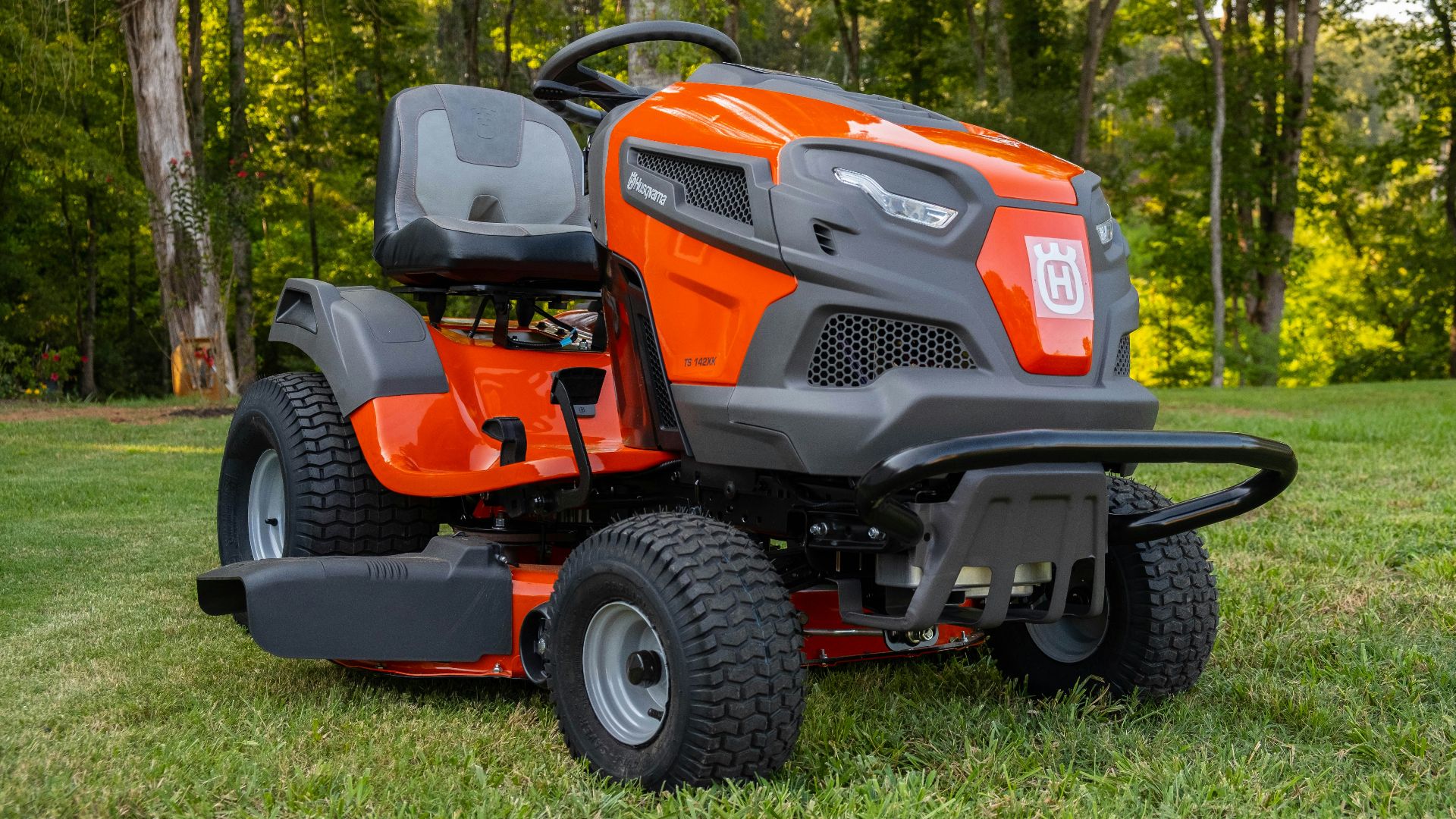 orange and black ride on lawn mower on green grass field during daytime