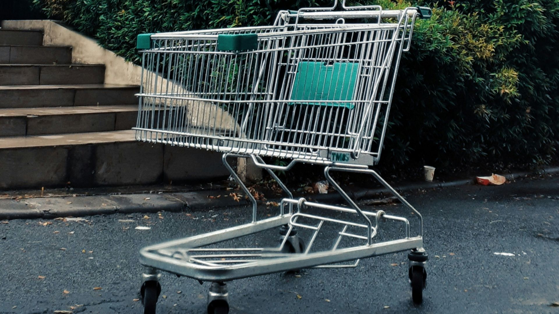 green shopping cart on gray concrete stairs