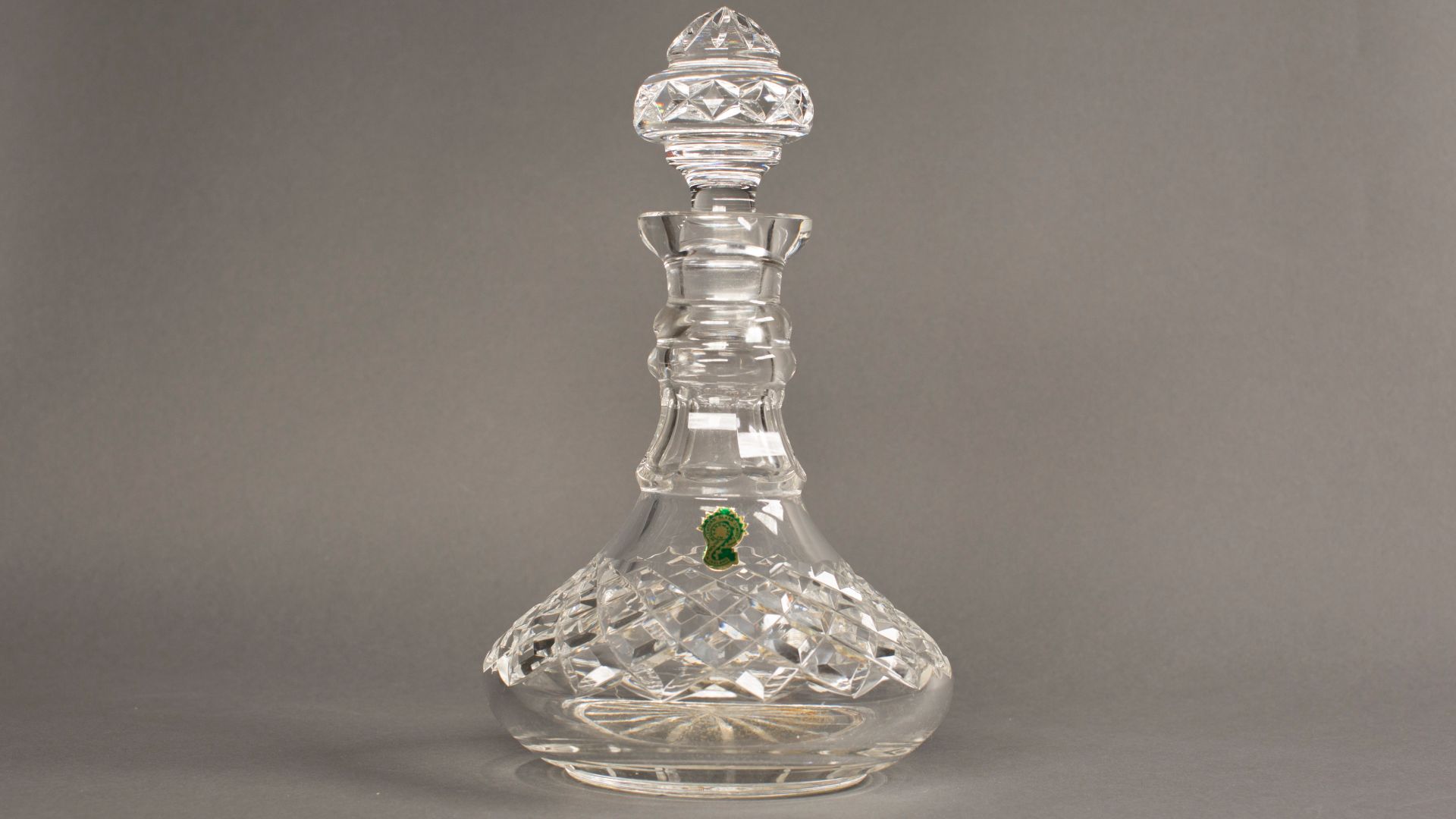 This is a ship style Waterford Crystal decanter with a stopper, with a brass plaque that states,