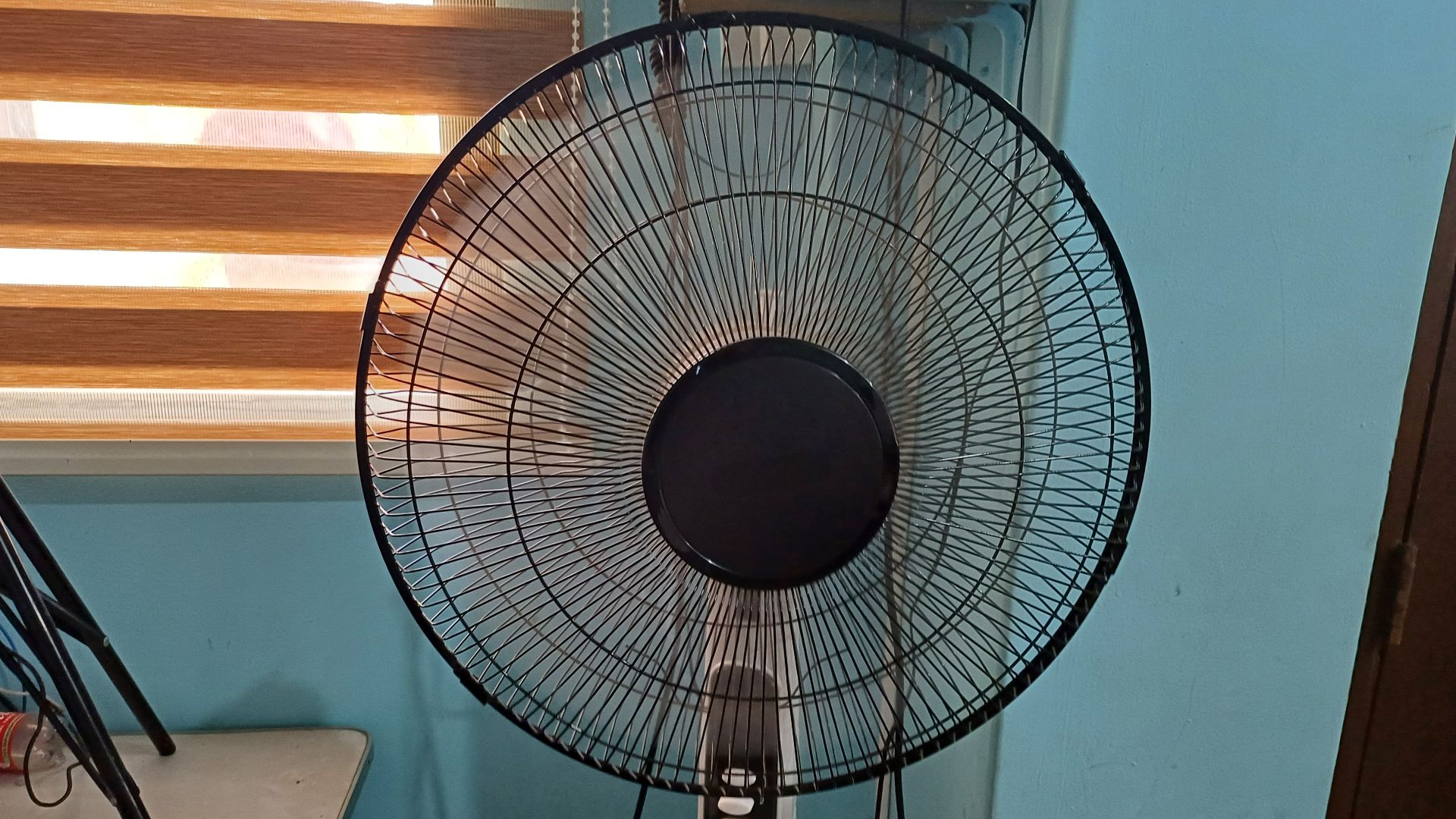 A modern BLAKK electric fan with the company's logo removed at a school.