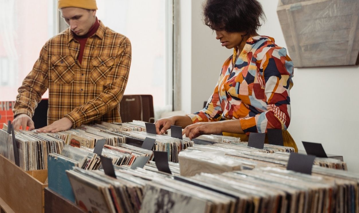 Two people browsing vinyl records in a retro-style store, indoors with vintage decor