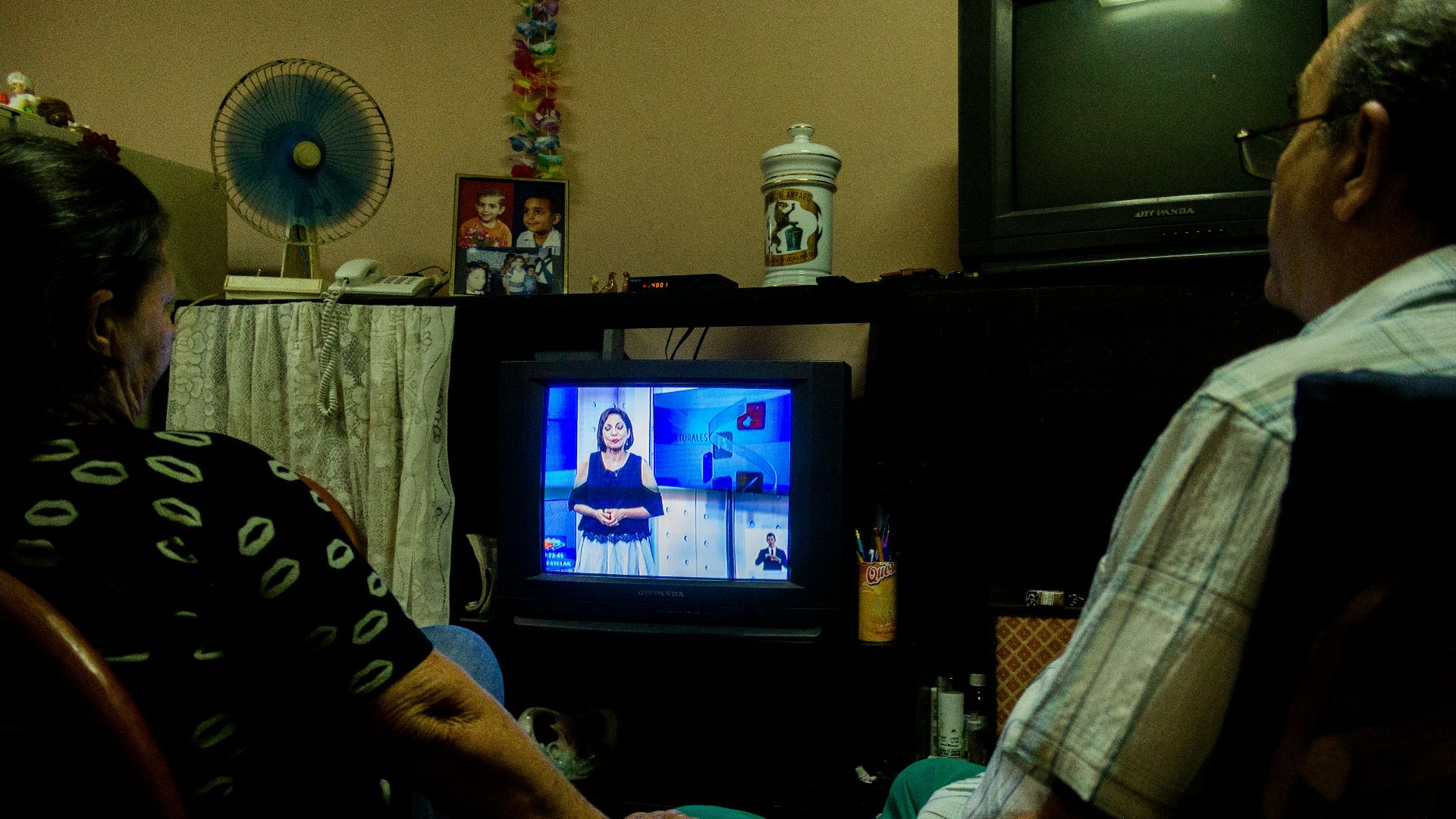 a man and a woman sitting in front of a tv