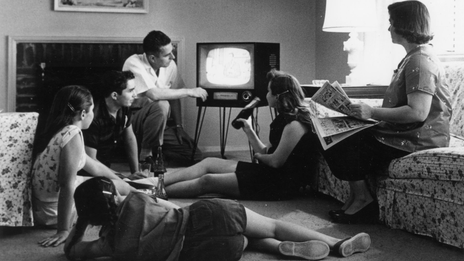 Family watching television in their home, c. 1958