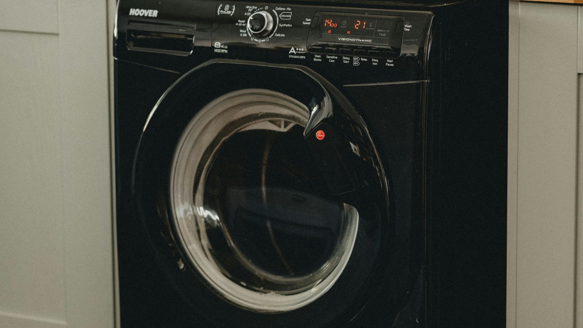 white plastic laundry basket beside black front load washing machine