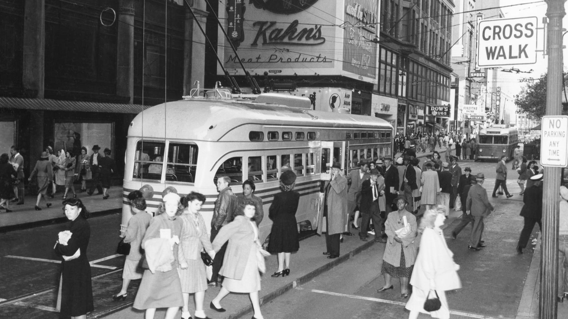 Downtown Cincinnati, Ohio, circa the early 1940s, looking northeast at 5th & Vine. A PCC streetcar is eastbound on 5th Street, and in the background a Mack trolleybus is westbound on route 15. In the upper center is the Kahn's Meat Products