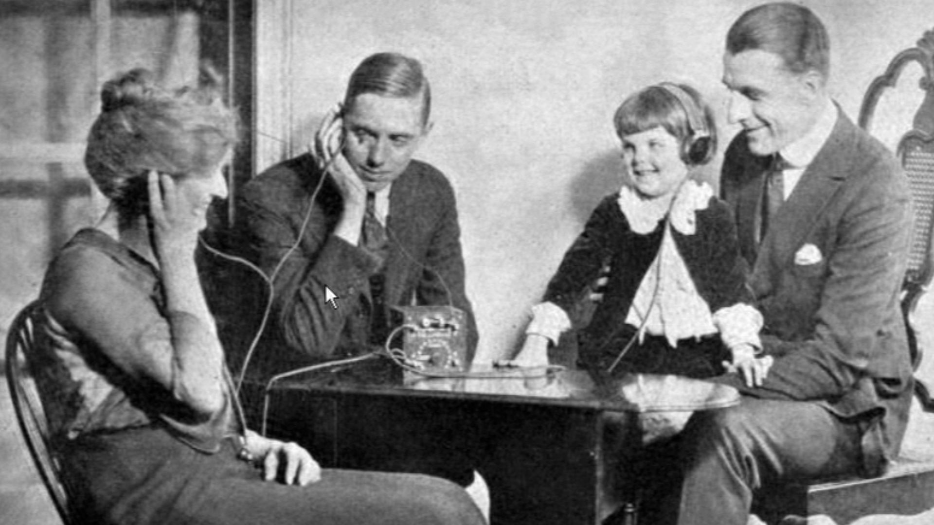 Photo of an American family in the 1920s listening to a crystal radio.   From a 1922 advertisement for Freed-Eisemann radios in Radio World magazine.  The small radio is on the table.  Crystal sets work off the power received from radio waves, so they are