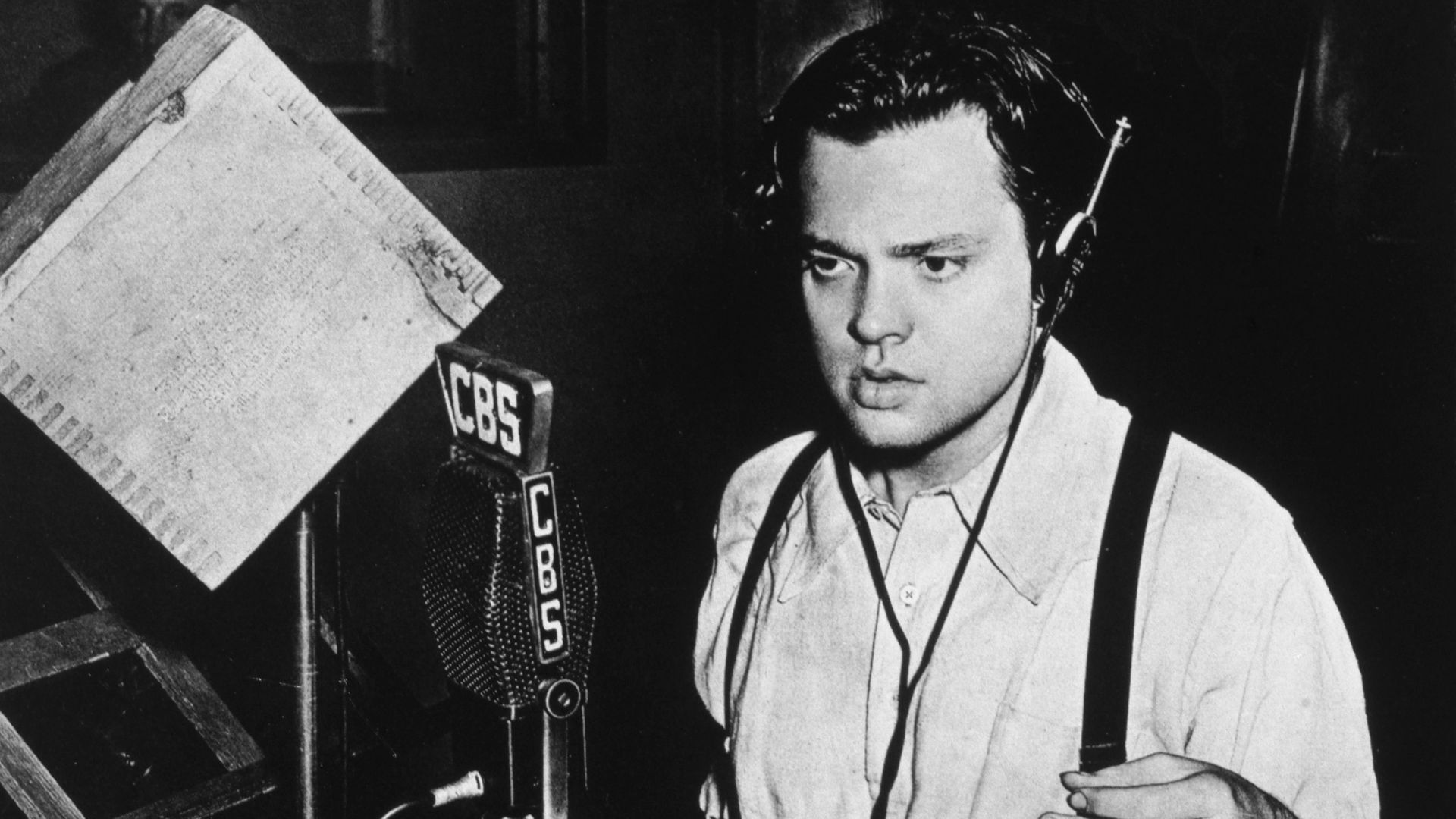 Photograph of Orson Welles at work in the CBS Radio studio, used in a feature story on the War of the Worlds broadcast