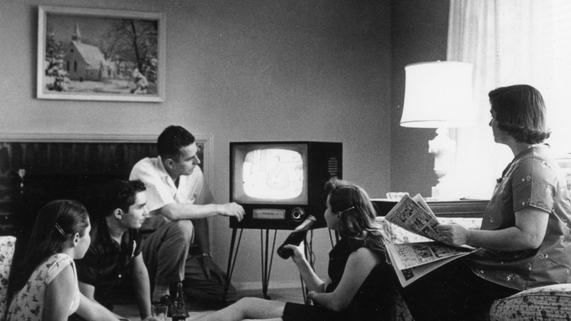 Family watching television in their home, c. 1958