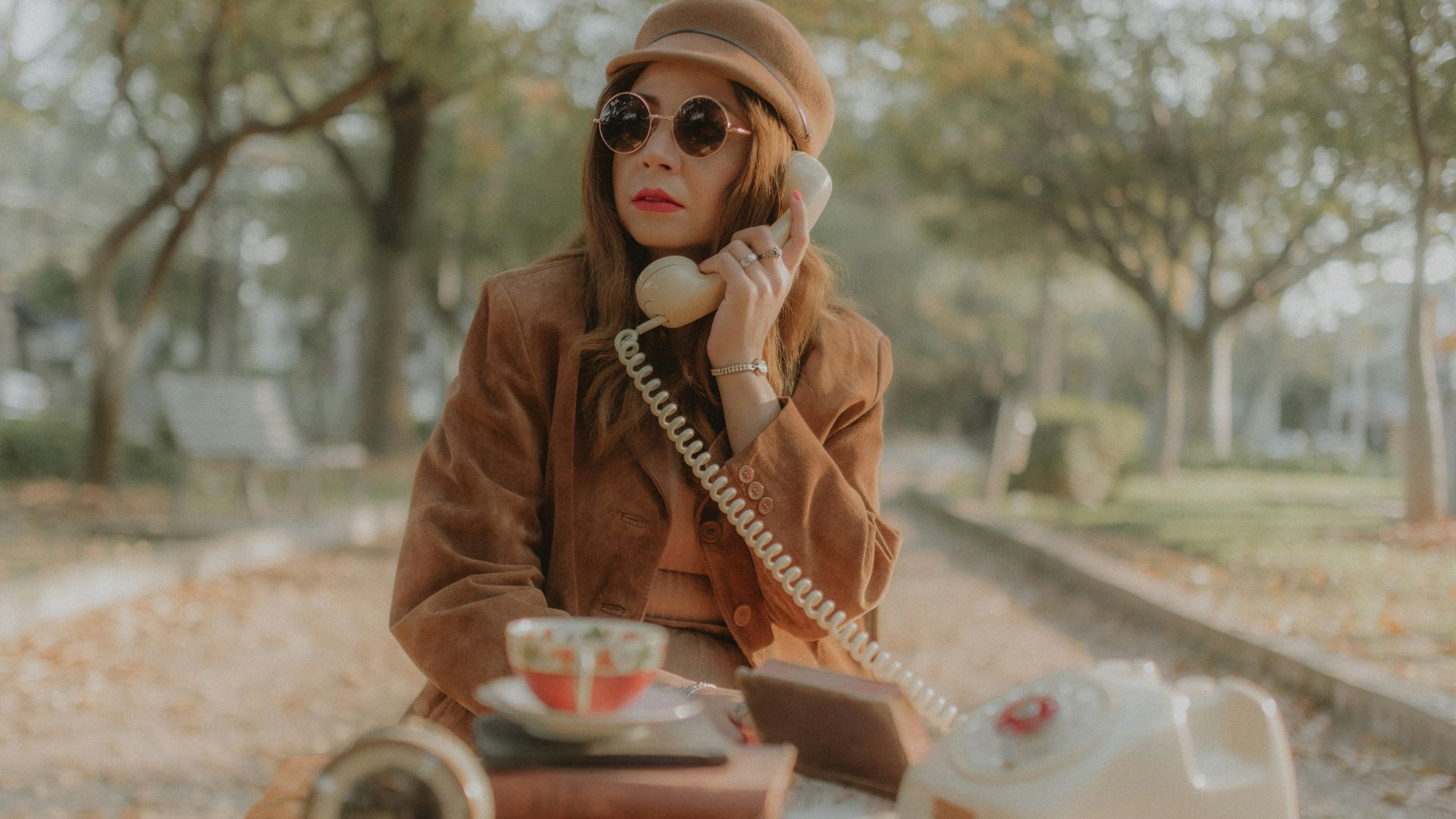 a woman sitting on the ground talking on a phone