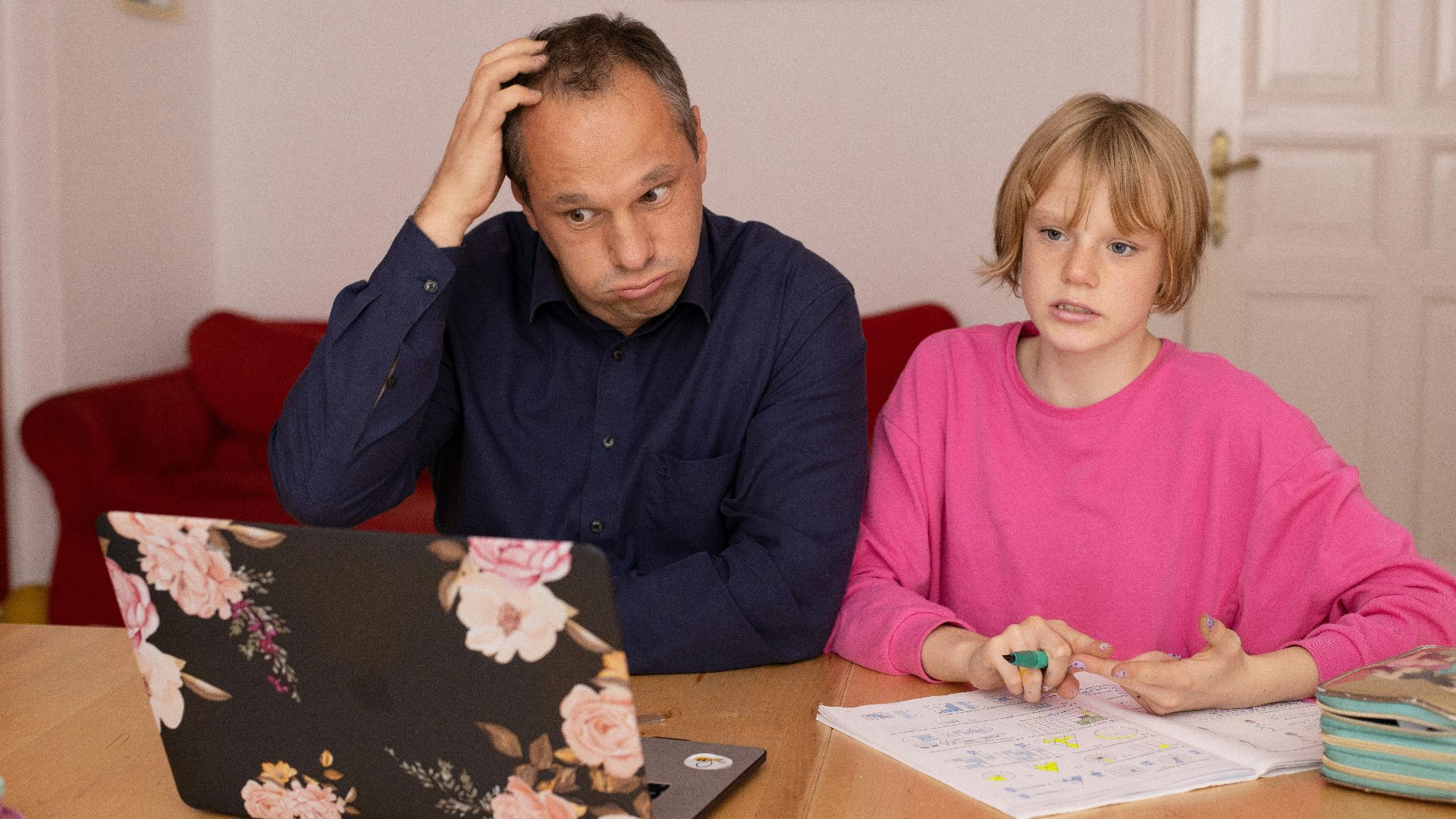 man in blue dress shirt sitting beside girl in pink long sleeve shirt