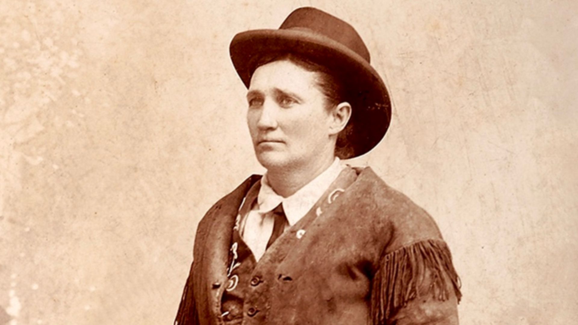 Cabinet photograph captioned in the negative, Calamity Jane, Gen. Crook's Scout. An early view of Calamity Jane wearing buckskins, with an ivory-gripped Colt Single Action Army revolver tucked in her hand-tooled holster, holding a Sharps rifle.