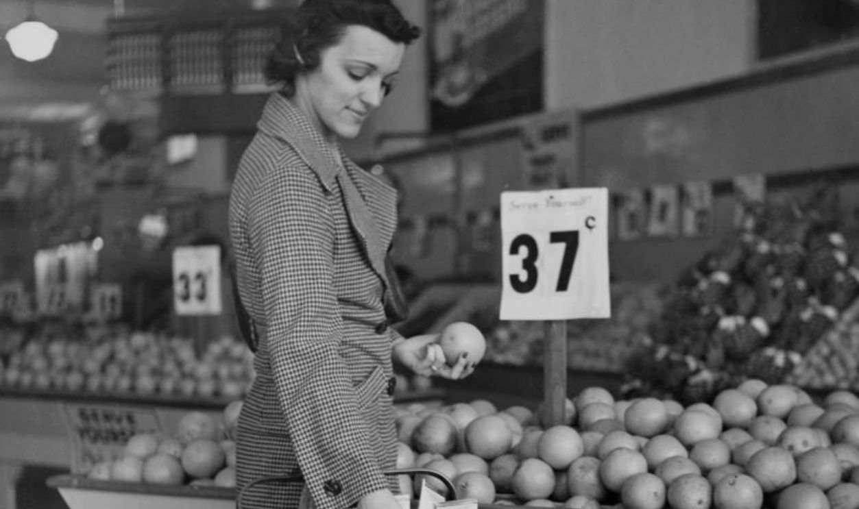 A woman wearing a checked suit as she places shopping in a small shopping cart at the A&P grocery store in Ambler, Pennsylvania, circa 1935. A&P is the abbreviated title of the Great Atlantic & Pacific Tea Company chain of grocery stores.