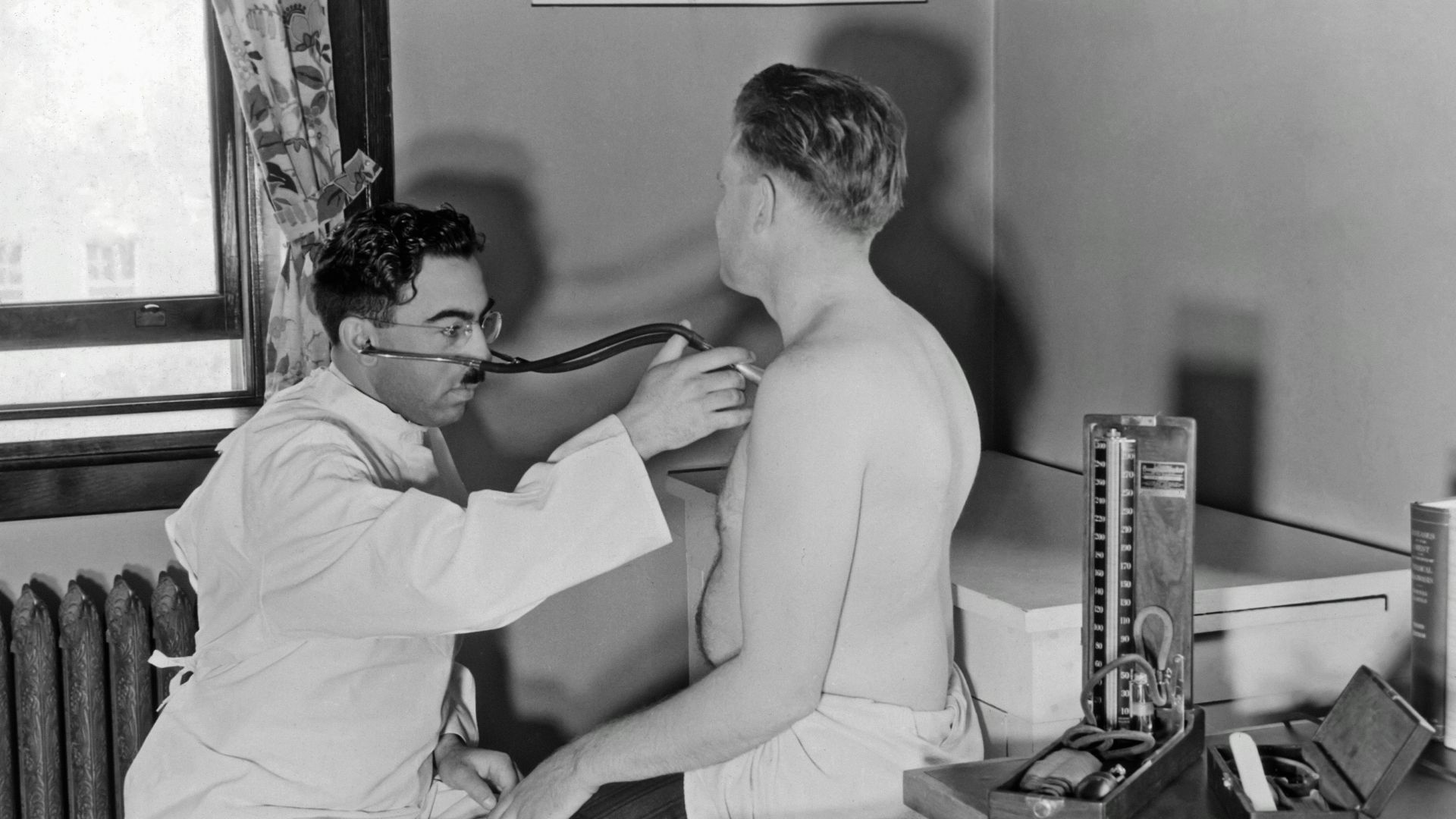 a black and white photo of a man brushing his teeth