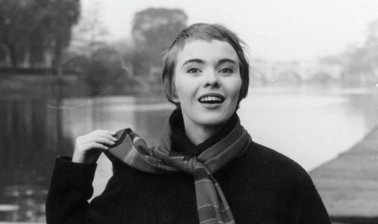 circa 1957: Portrait of American actor Jean Seberg (1938 - 1979) with her trademark gamine haircut, overcoat, and long fringed scarf, standing in front of the River Thames, where director Otto Preminger filmed his 'Saint Joan', in which she starred, London, England.