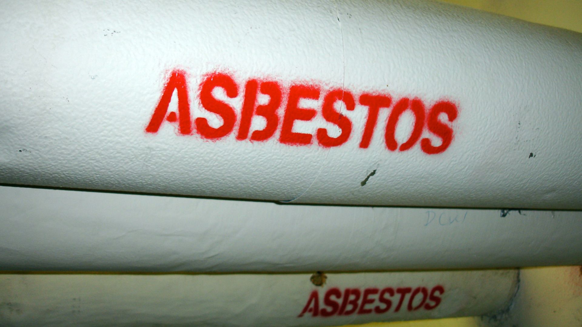 One of many pipes on campus wrapped in asbestos insulation, clearly marked.
